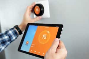 A homeowner uses his tablet to adjust the temperature in his home and lower his energy costs. 