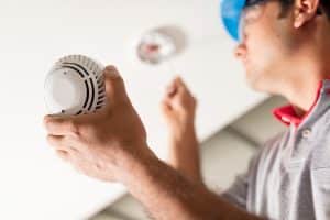 A licensed electrician installing a new smoke detector in a St. Charles, Missouri home.