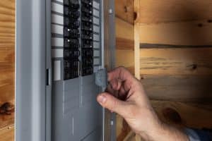 A man checking his breaker to see the load. 