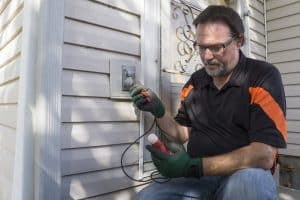 A licensed electrician testing an outdoor GFCI outlet. 